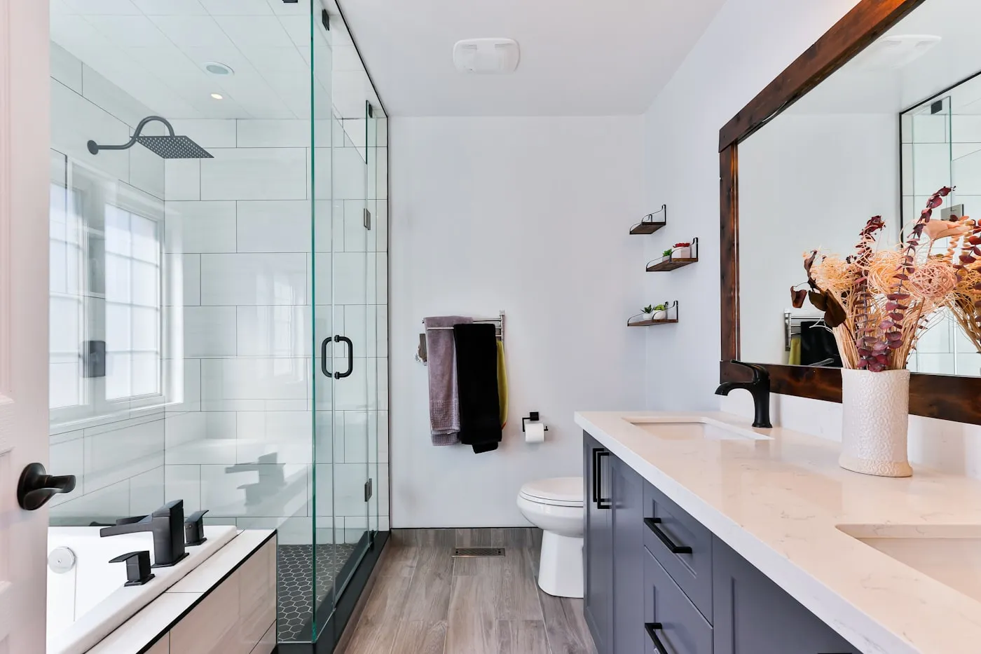 Baño reformado con ducha de vidrio, rociador y grifería nueva